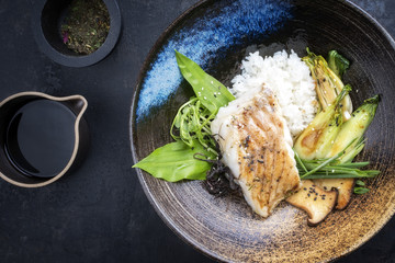 Modern japanisch Kabeljau Fisch Filet gebraten mit Pak Choi und Reis als Draufsicht  in einer Schale