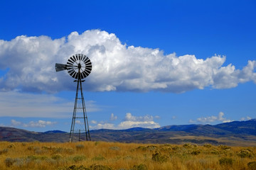 Windmill on Hillside in Countryside Rural America with Sky and Clouds