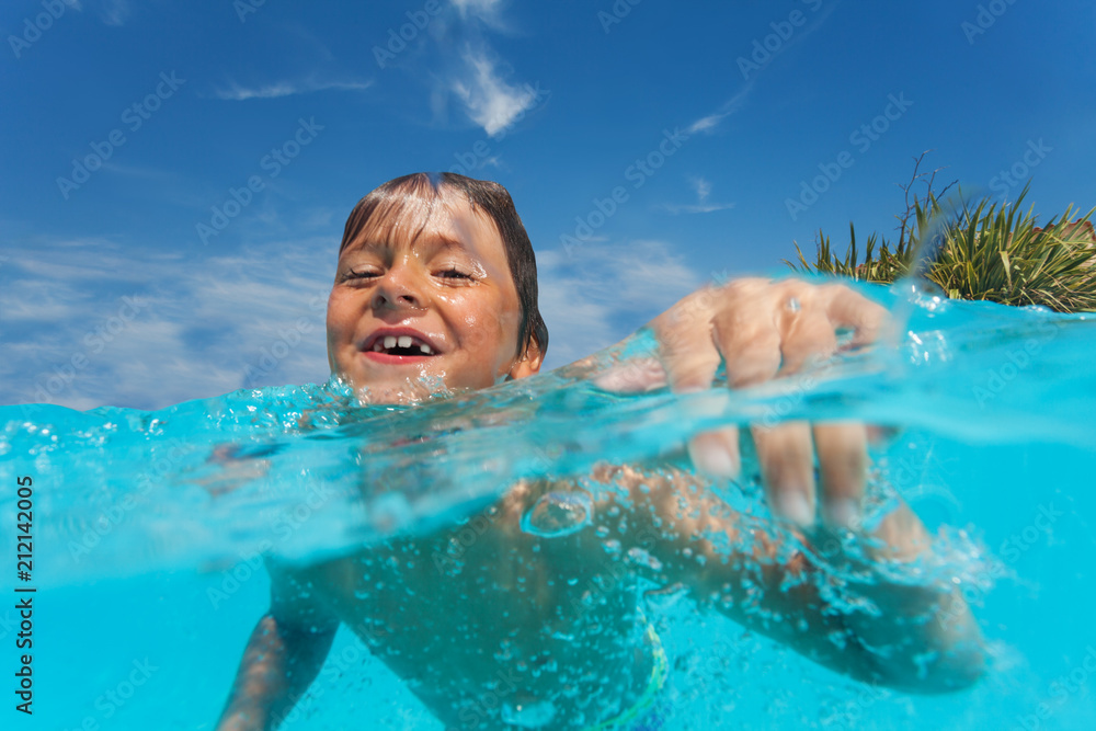 Wall mural Happy preteen boy swimming in outdoor pool