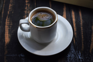 morning hot coffee on the table near the book