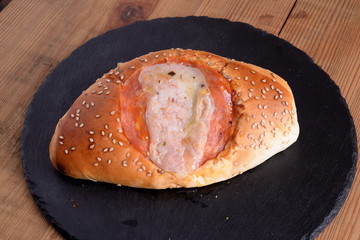 Baked calzone stuffed with ham and mozzarella and spicy salami  