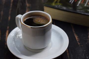 morning hot coffee on the table near the book
