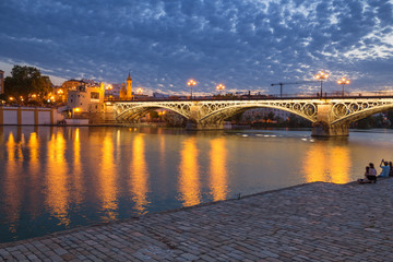 Seville, Spain, Night view of the bridge and fashionable and historic districts of Triana