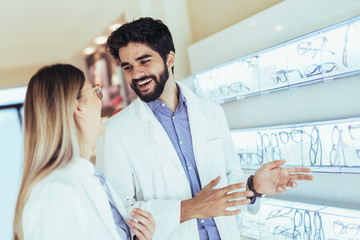 Obraz premium Portrait of a pair of ophthalmologists, who makes eye-ophthalmological viewing for a client in an optical center.