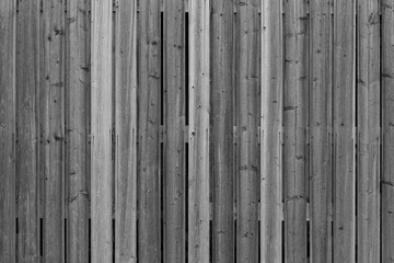 Full frame background of an unpainted wood board wall in black and white