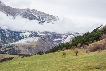 green meadow on the background of mountains buried in the clouds. ingush republic.