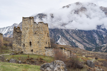 Destroyed tower complex on the background of mountains in the clouds. ingush republic