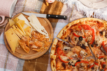 Pizza and cutted cheese on plates