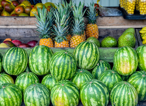 estante de madera en un mercado de granjeros de frutas con patillas, pi&ntilde;as, mangos entre otras frutas tropicales y org&aacute;nicas 