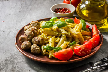 Pasta with pesto sauce and meatballs