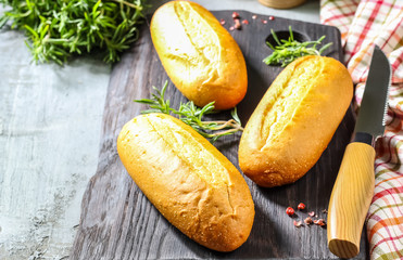 homemade wheat baguettes on on a black cutting