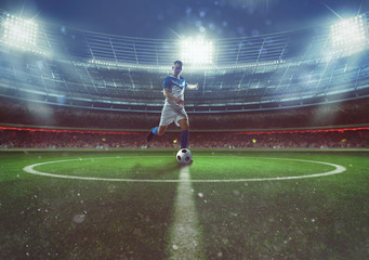 Soccer player hits the ball from the midfield at the stadium