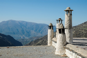 A group of four chimney pots on the roof of a house in the traditional design for the Alpujarra...