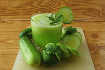 
green juice garden fresh cucumber juice on wooden background