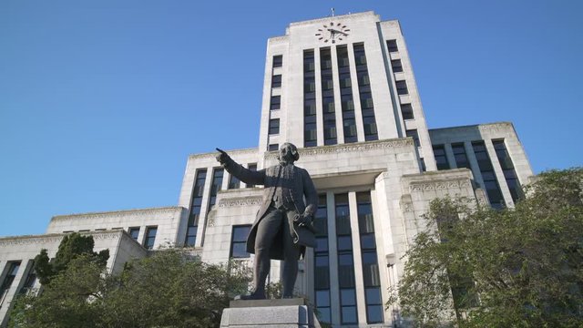 Captain Vancouver Statue, City Hall, Vancouver dolly shot 4K, UHD. The exterior of the Vancouver City Hall building with a statue of Captain Vancouver in front. 4K, UHD.
