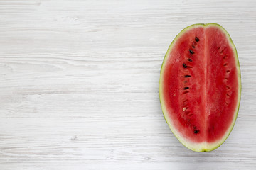Fototapeta na wymiar Fresh cut watermelon on a white wooden surface, top view. From above, overhead. Copy space.