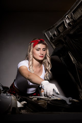 Fototapeta na wymiar girl mechanic in the garage, pin up