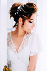 Tender elegant young bride with hairdo, hairpin and bridal makeup