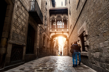 Woman tourist sightseeing in Barcelona Barri Gothic Quarter and Bridge of Sighs in Barcelona, Catalonia, Spain.. - obrazy, fototapety, plakaty