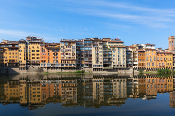 Fototapeta na wymiar Colorful houses are mirrored in riiver. Florence, Italy