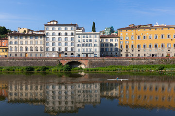 Fototapeta na wymiar Colorful houses are mirrored in riiver. Florence, Italy