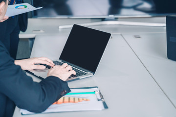 positive young business man sitting and working with documents and laptop,