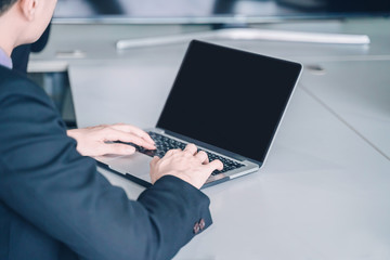 positive young business man sitting and working with documents and laptop,