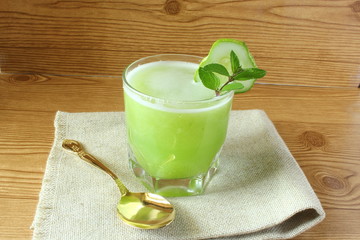 
green juice garden fresh cucumber juice on wooden background