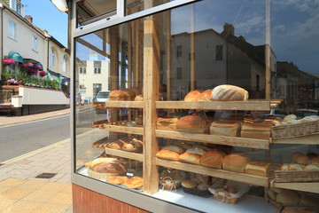 Shelves filled with freshly baked loaves of  bread diplayed in shop window in town of Sidmouth,...