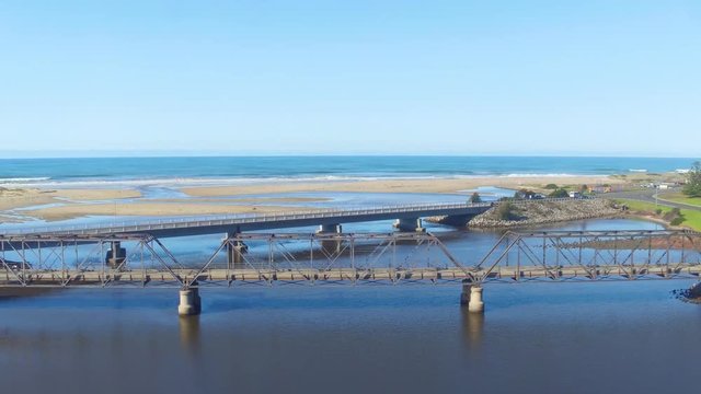 Fflying under bridge to reveal expansive beach on a sunny day. Pristine, untouched beach without any people. Located at Scamander Tasmania.