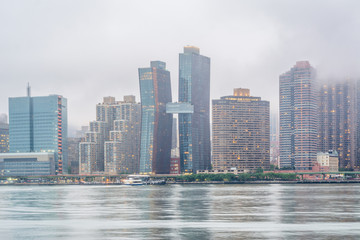 Foggy view of the Manhattan skyline from Gantry Plaza State Park, in Long Island City, Queens, New York City.