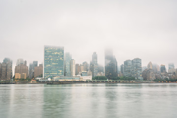 Naklejka premium Foggy view of the Manhattan skyline from Gantry Plaza State Park, in Long Island City, Queens, New York City.