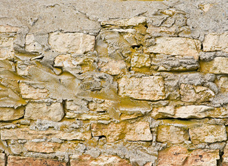 Natural carved stone wall  made of sandstone. Rough fractured surfaces. Stone wall background texture. 