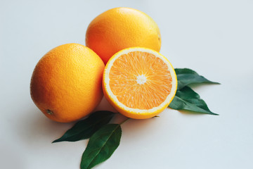 Half and whole oranges close up on a gray background.