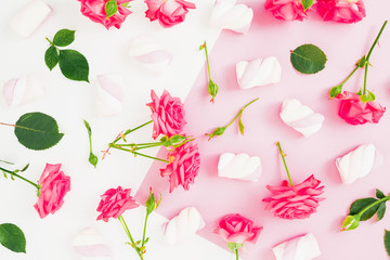 Pink pastel background with roses and marshmallow candy. Flat lay. Top view
