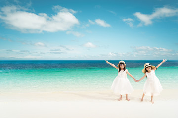 Fototapeta na wymiar Portrait of happy asian sister at sandy beach in summer vacation .
