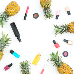 Frame with pineapple fruits and feminine cosmetics on white background. Flat lay, top view.