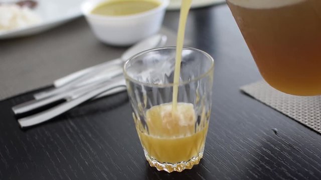 Pouring lulo juice in a small crystal glass