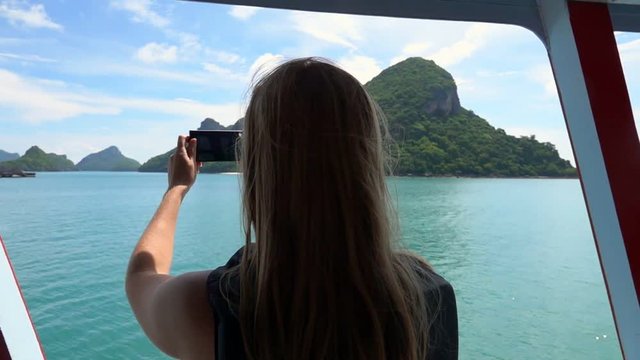 Silhouette of Young Female Tourist Taking Photo of Tropical Islands on Mobile Phone