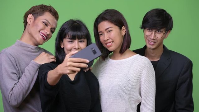 Group of happy Asian friends taking selfie together