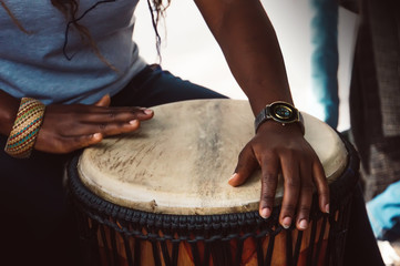 Close up of hands of a woman playing a drum.
