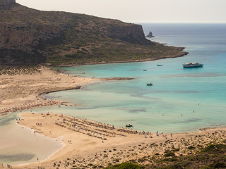 Balos lagoon and beach on Crete island. Tourists relax and bath in crystal clear water. Greece, june 2018