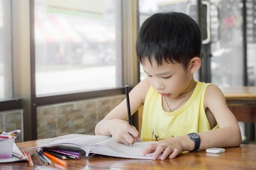 Little boy doing homework for school on the desk at home