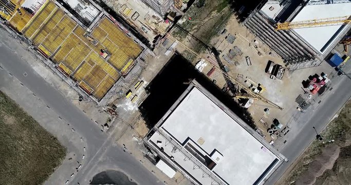 Aerial view from a greater height above the cranes of a construction site with the carcasses for new apartments in a growing German city, nadir aerial footage, made with drone