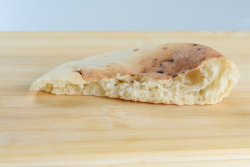 Perfect half pita bread with air bubbles  in the dough on wooden board .