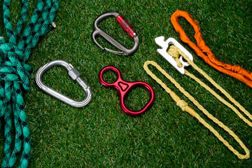 on the green lawn different set of items for sports and raising to height, carabiners, ropes.