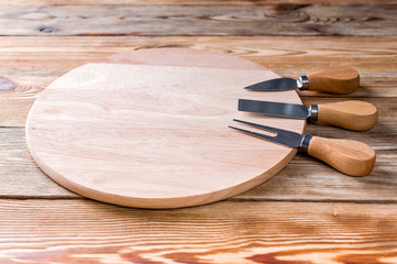 Round cutting board and a set of knives for cheese.