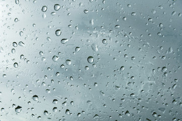 Textured background of window panes with a cloudy background. Natural pattern from a drop of rain on a cloudy background.