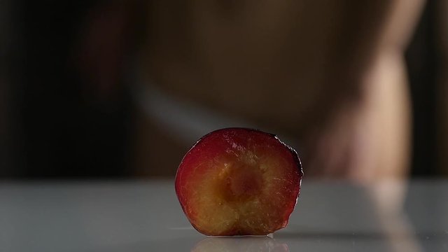 close-up half peach, woman takes off and puts on her panties. imitation vagina. slow motion