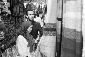 Fototapeta na wymiar Smiling young muslim couple shopping carpets in a textile store
